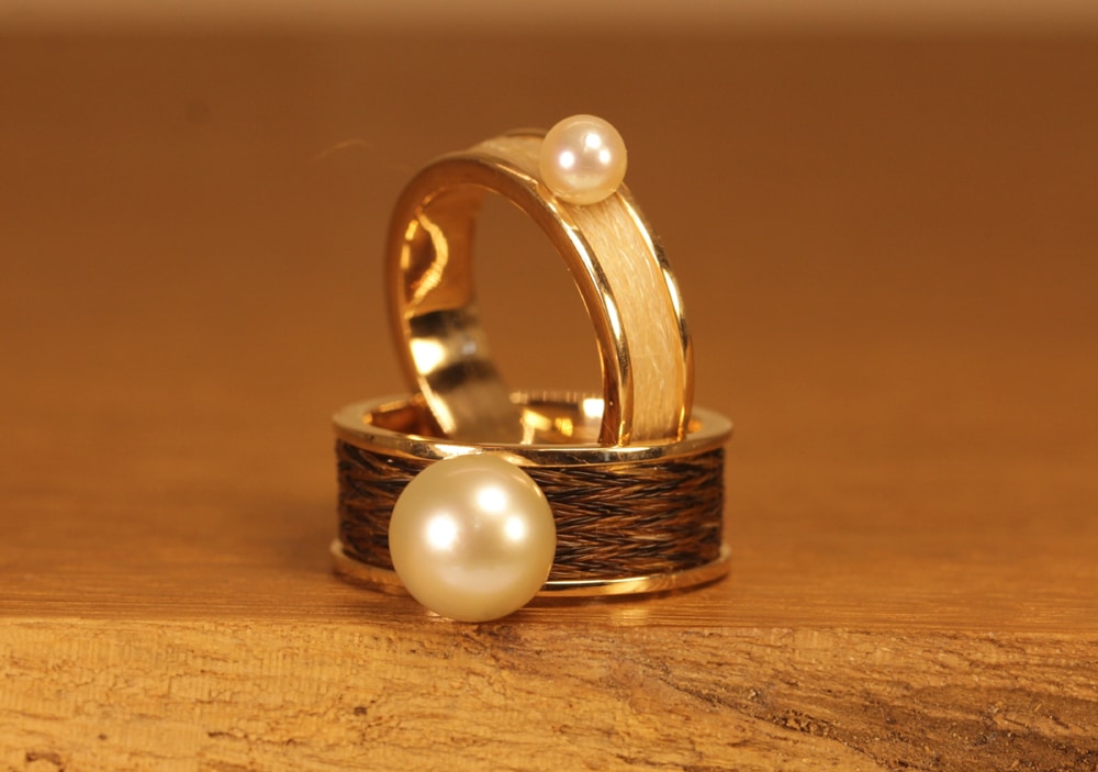 Due anelli in oro con perla e crine di cavallo intrecciato