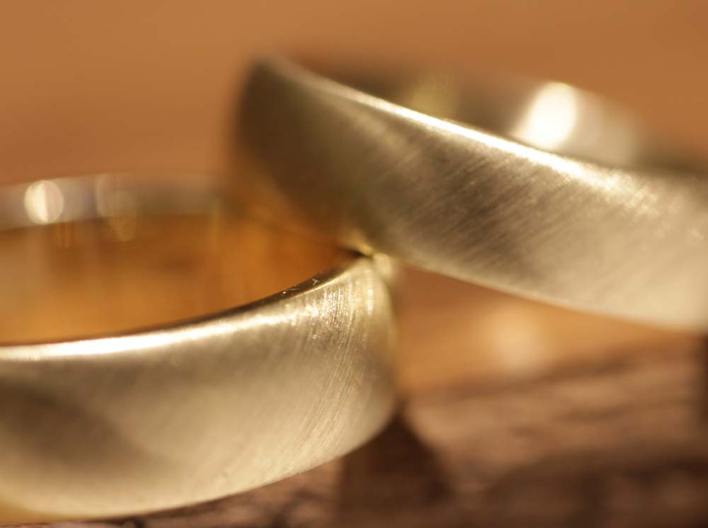 Image 026a: wedding rings made of yellow gold, diagonally brushed, matt.