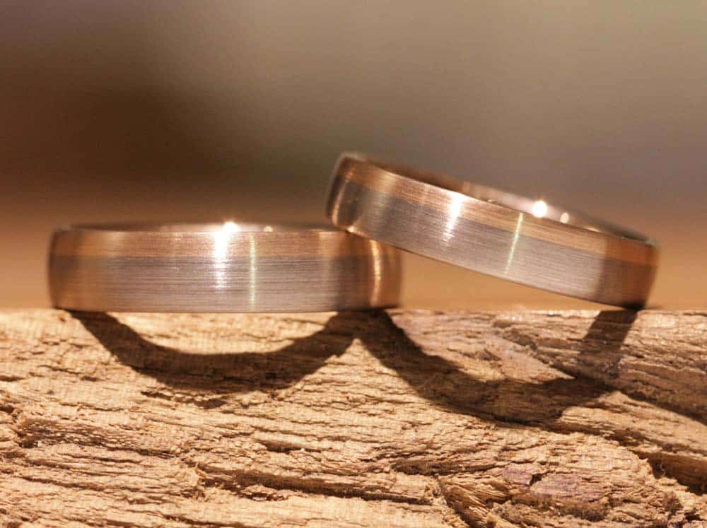 Image 035a: timelessly modern wedding rings, two-tone with a color gradient from gray gold to red gold.