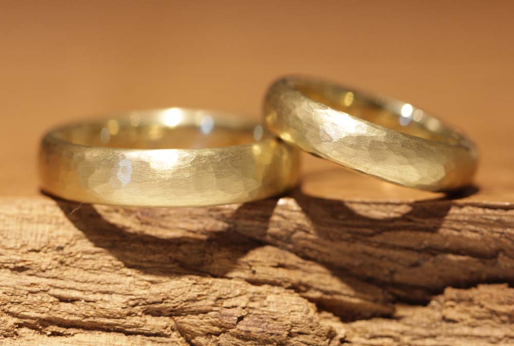 wider oval yellow gold wedding rings with hammer finish made in schmuckgarten