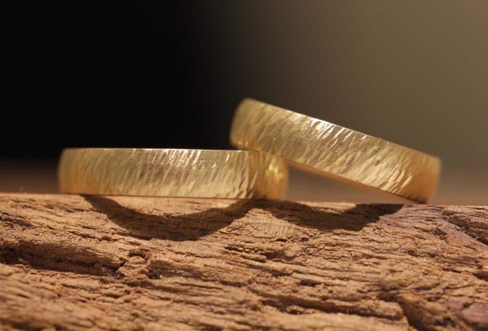 Custom-made, wedding rings made of yellow gold, forged surface with the fin