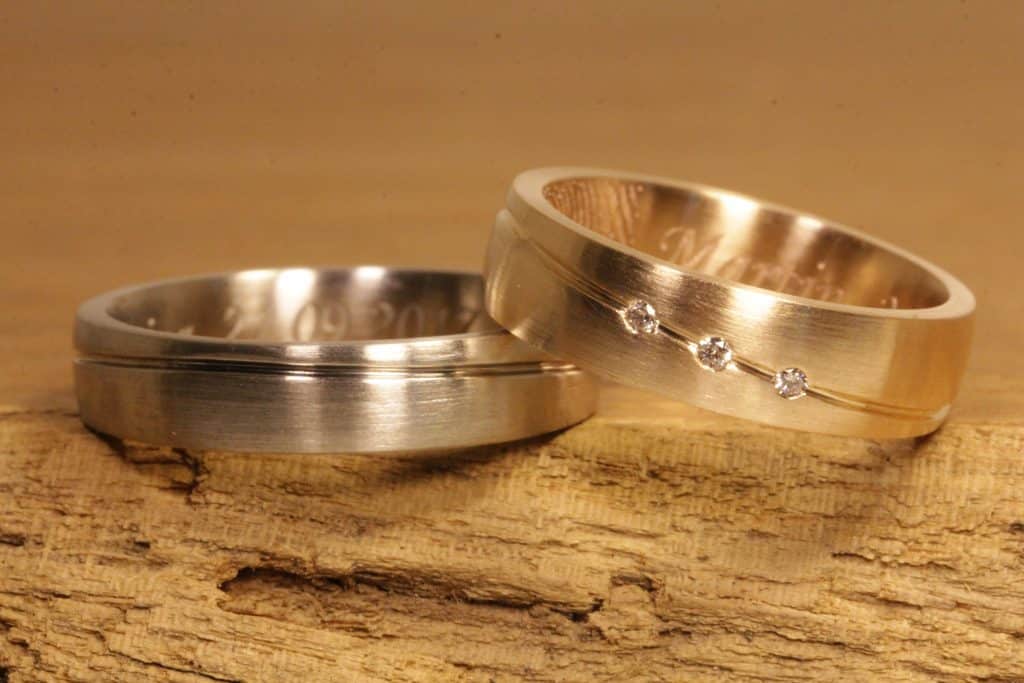 Imagen 189a: Alianzas de líneas onduladas, oro rosa y oro gris, tres diamantes talla brillante en el anillo de mujer.