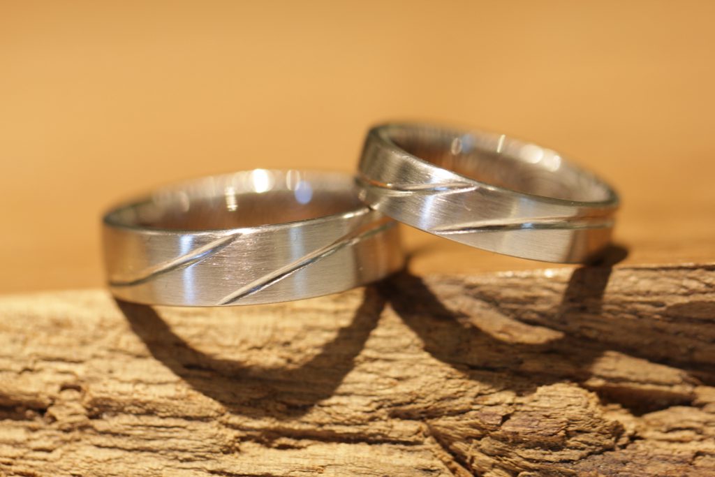 Image 193: Pair of wedding rings with line drawing on the outside in white gold.