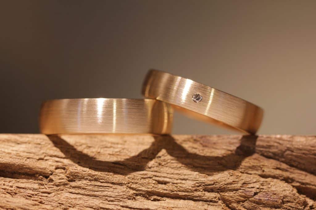 Cuadro 196a: anillos de boda atemporalmente elegantes en oro rojo, un pequeño diamante de talla brillante en el anillo de mujer.