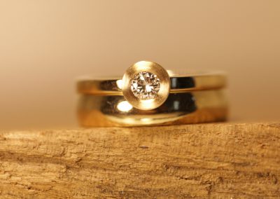 Gold solitaire ring next to wedding ring Schmuckgarten
