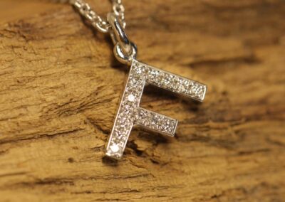 Letter pendant "F" set with brilliant-cut diamonds