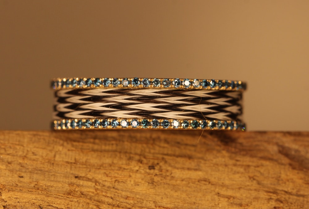 Gold ring with woven horse hair and blue diamonds