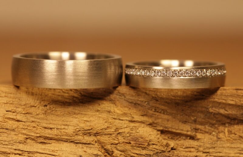 A pair of matt-cut wedding rings made of 750 gray gold. Ladies' ring with brilliant-cut diamonds