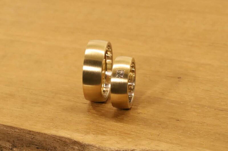 Un par de anillos de boda hechos de un anillo de mujer de oro amarillo 750 con diamante princesa