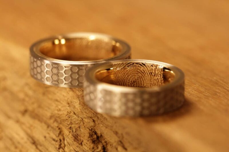 Beautiful wedding rings made of 750 white gold and rose gold with honeycomb engraving on the outside. Ladies ring with diamonds and fingerprint on the inside