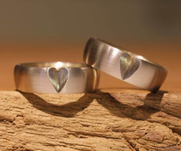 Two-tone wedding rings outside gray gold inside yellow gold with a heart