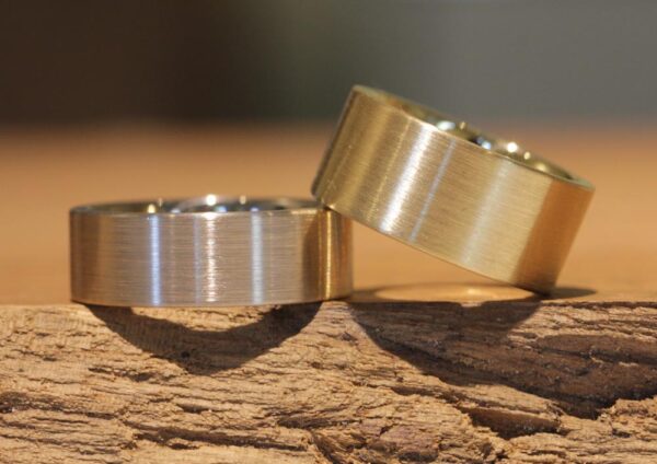 A pair of wedding rings, wide 585 white gold and yellow gold, matted lengthways