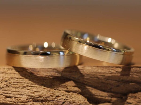A pair of wedding rings with a matt and polished surface in 750 yellow gold