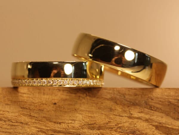 Un par de anillos de boda pulidos en oro amarillo 750. Anillo de mujer con diamantes blancos alrededor