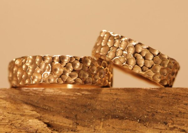 Exceptional wedding rings made of 585 red gold rock-like surface bubbles