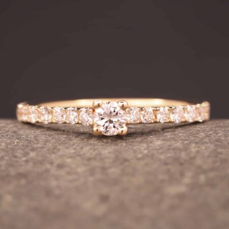 verlobungsring in rose gold mit großen diamant und kleinen diamanten in der ringschiene