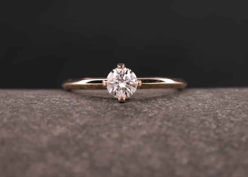 anillo solitario de oro rosa con diamante en montura de cuatro puntas
