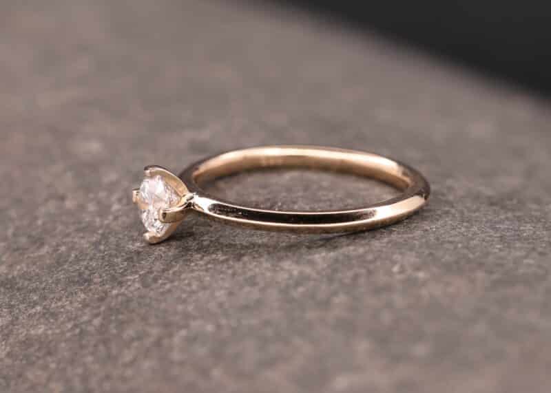 anillo solitario de oro rosa con diamante en montura de cuatro puntas