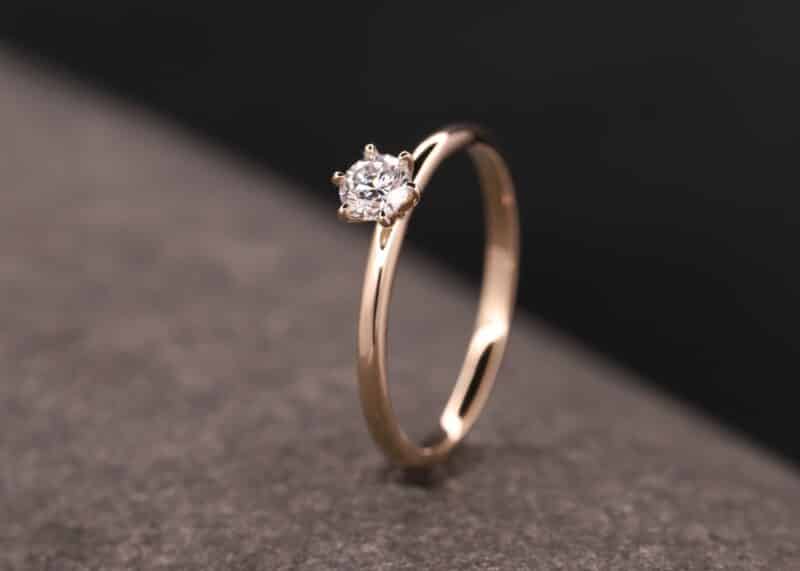 anillo de oro rosa con un brillante en una montura de seis garras