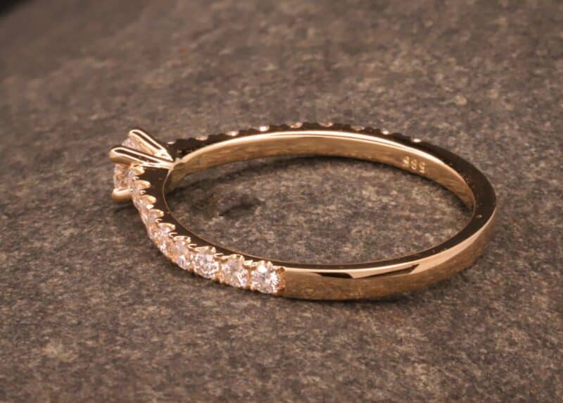 bague de fiançailles en or rose avec un gros diamant et de petits diamants dans l'anneau