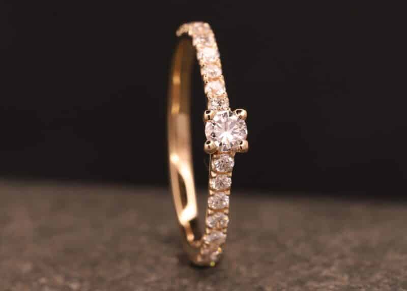 engagement ring in rose gold with a large diamond and small diamonds in the band